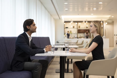Two trainee solicitors discussing in the Penson Lounge,